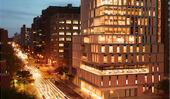The NYU Dentistry building lit up at night.