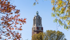 An image of autumn trees around a college campus building.